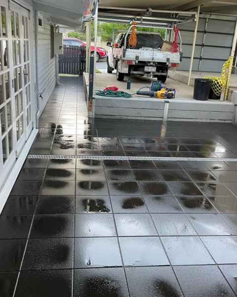 After: the same side area laid with large dark grey tiles