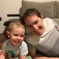 Smiling man and young boy together in a lounge room