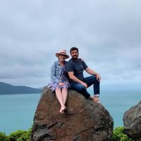 Couple sitting on a large rock above the sea