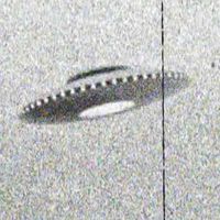 Grainy black and white photo of a flying saucer shape